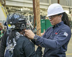 Andrea Simmons helps a Women’s Climb Clinic participant put on her personal protective equipment. Andrea Simmons helps a Women’s Climb Clinic participant put on her personal protective equipment.