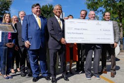 ComEd CEO Gil Quinones presents the Village of Skokie with one of the first fleet EV rebate checks as part of its BE Plan 1, next to Gov. J.B. Pritzker. ComEd CEO Gil Quinones presents the Village of Skokie with one of the first fleet EV rebate checks as part of its BE Plan 1, next to Gov. J.B. Pritzker.