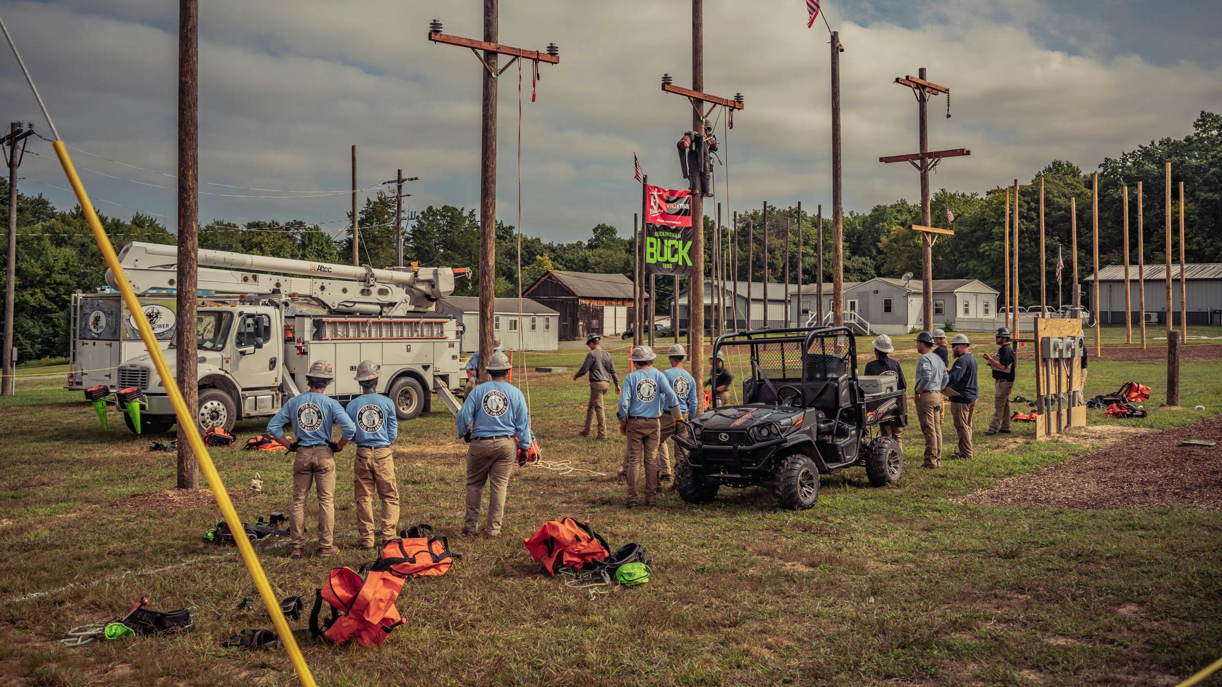 lineworkers standing by power poles