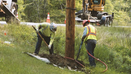 utility workers placing poles