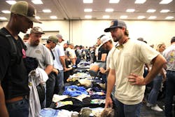 Lineworkers lay out their T-shirts on a long table in a new area open for the 2025 Trade Night. Lineworkers lay out their T-shirts on a long table in a new area open for the 2025 Trade Night.