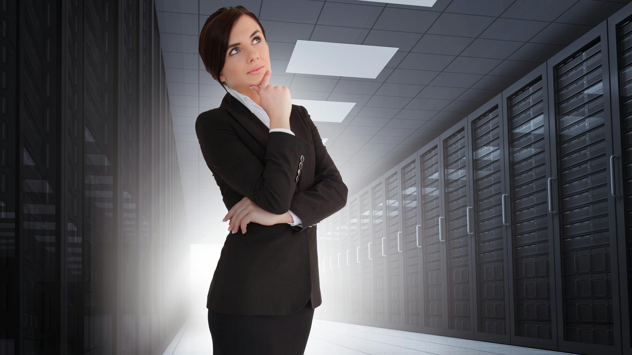 Businesswoman looking thoughtful in data center with light shining in the darkness