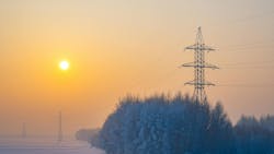 Winter morning landscape of snow covered nature, trees and large poles of high voltage power transmission lines Winter morning landscape of snow covered nature, trees and large poles of high voltage power transmission lines