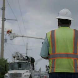A job site manager oversees a lineman working from his bucket. A job site manager oversees a lineman working from his bucket.