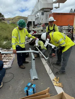 Crews assemble a sensor crossarm for temperature, humidity, and wind sensors before mounting on the utility pole. Crews assemble a sensor crossarm for temperature, humidity, and wind sensors before mounting on the utility pole.