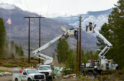 Mountain Parks Electric lineworkers repair a utility pole in Grand Lake, Colorado, featuring burn from the East Troublesome Fire in the background. Mountain Parks Electric lineworkers repair a utility pole in Grand Lake, Colorado, featuring burn from the East Troublesome Fire in the background.