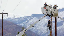 worker in bucket truck in front of mountains worker in bucket truck in front of mountains