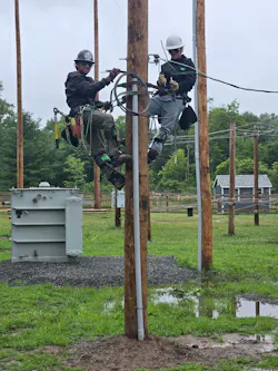 Bill White, shown in the L.I.N.E. training yard, explains how to work on secondary connections to his son, Liam, who graduated from the Lineman Institute of the North East in August.