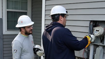 Cherryland staff (left to right), Dustin VonBuskirk and John Raasio, install a new Sensus meter on a member&rsquo;s home.