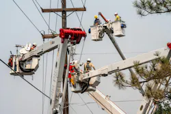Avista Utilities lineworkers work together to safely secure power lines on a utility pole in Spokane County, Wash.