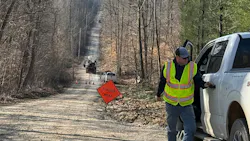 Chris O’Neal, head of vegetation management at SCI-REMC, is shown wearing a hi-vis vest on an active work scene with flagger signage.