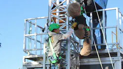 A participant scales a ladder to rescue a giant teddy bear during the 2026 International Lineman's Rodeo competition.